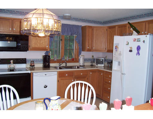 29 Vann Street Springfield, MA 01119 - Photo 6 of 13 a kitchen with a refrigerator a sink dishwasher and wooden cabinets with a dining table