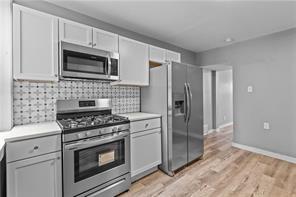 363 44th Street Pittsburgh, PA 15201 - Photo 7 of 14 a kitchen with white cabinets and stainless steel appliances