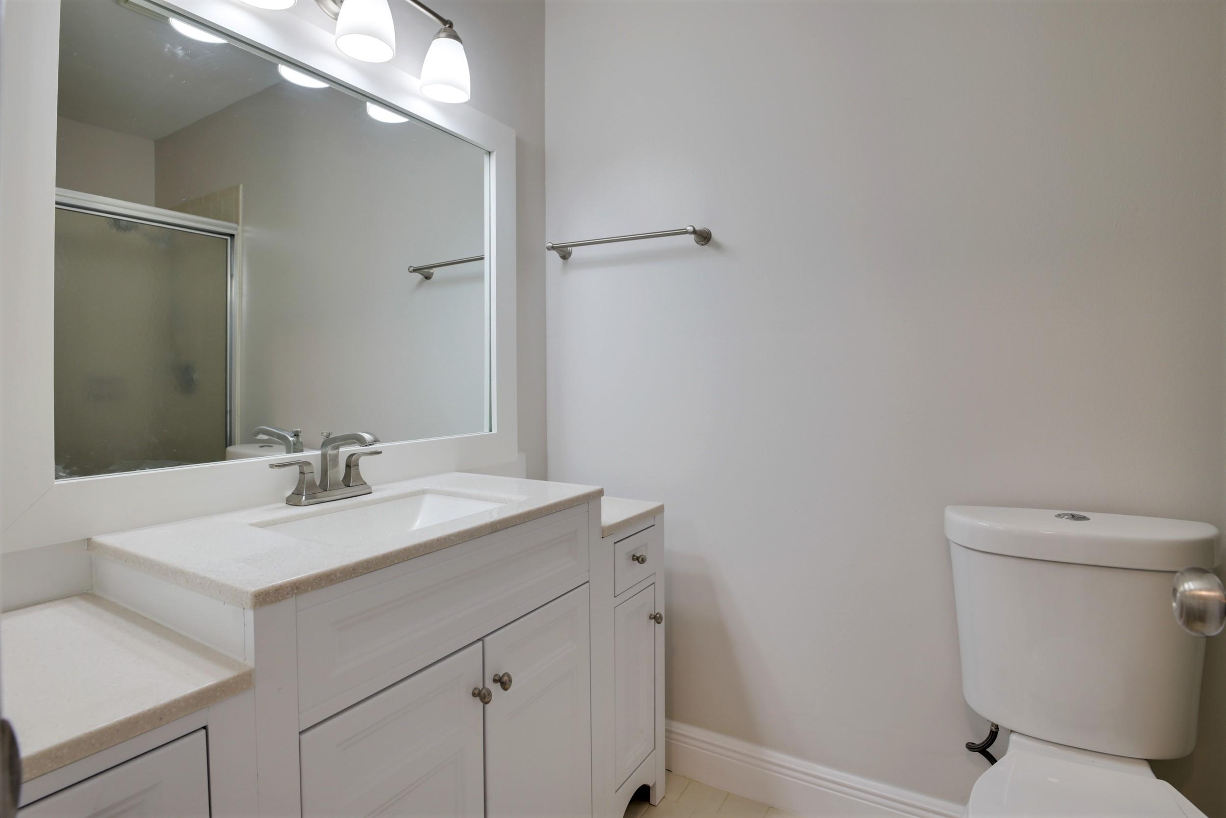 484 Springdale Circle, Unit 48D Palm Springs, FL 33461 - Photo 20 of 59 a bathroom with a sink toilet and a mirror