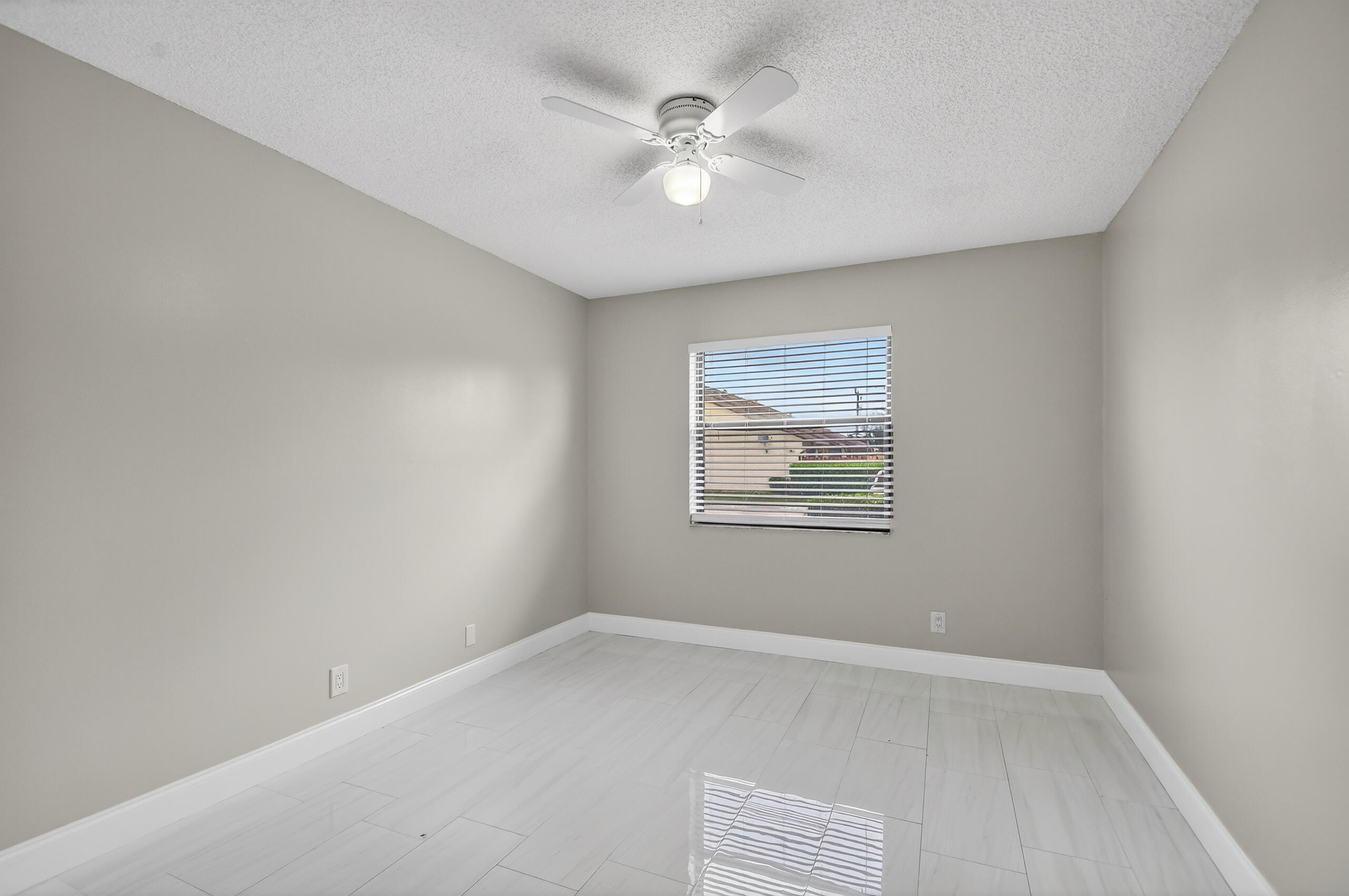 484 Springdale Circle, Unit 48D Palm Springs, FL 33461 - Photo 30 of 59 an empty room with a window and a ceiling fan