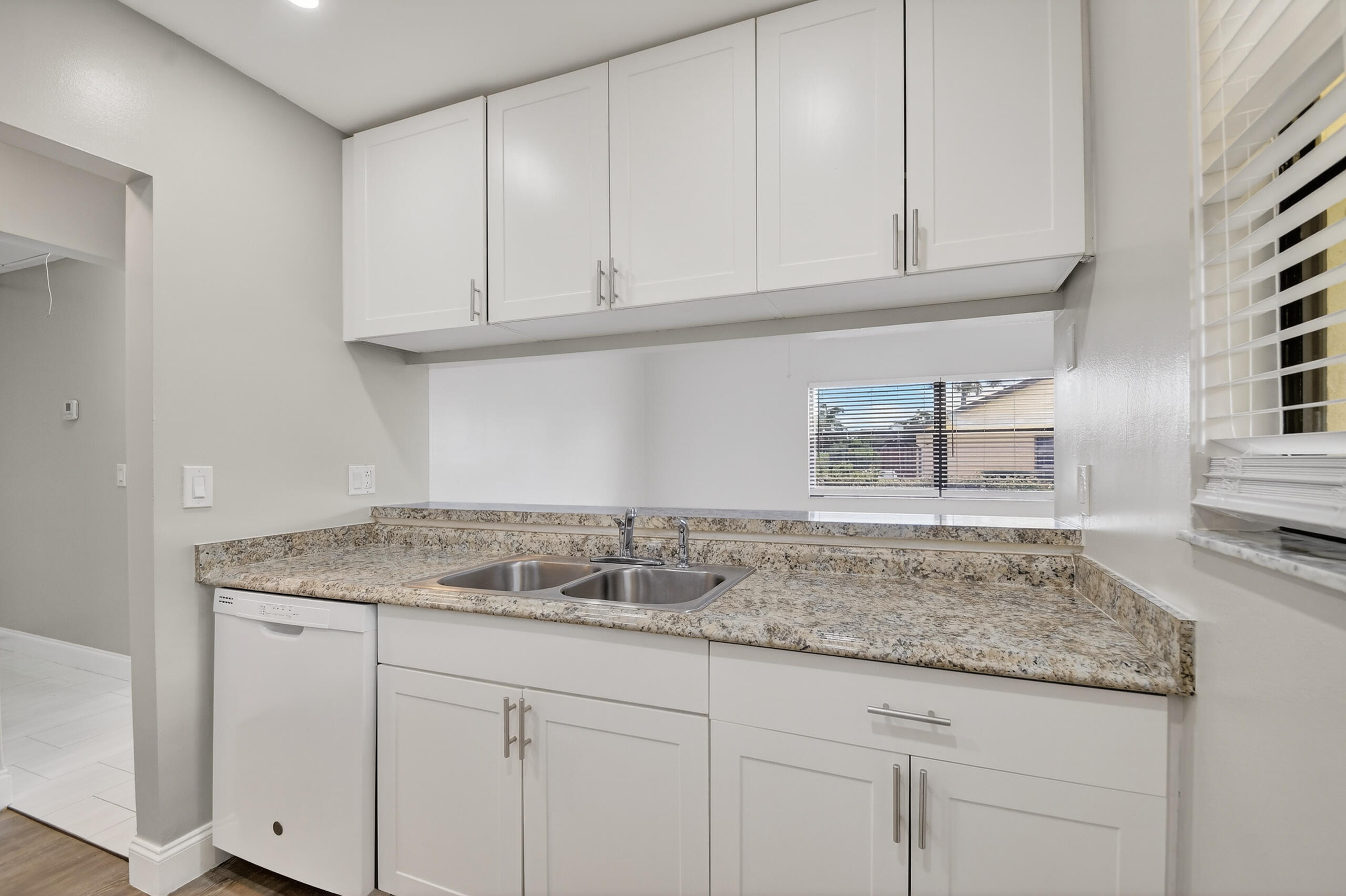484 Springdale Circle, Unit 48D Palm Springs, FL 33461 - Photo 5 of 59 a kitchen with granite countertop white cabinets and a sink