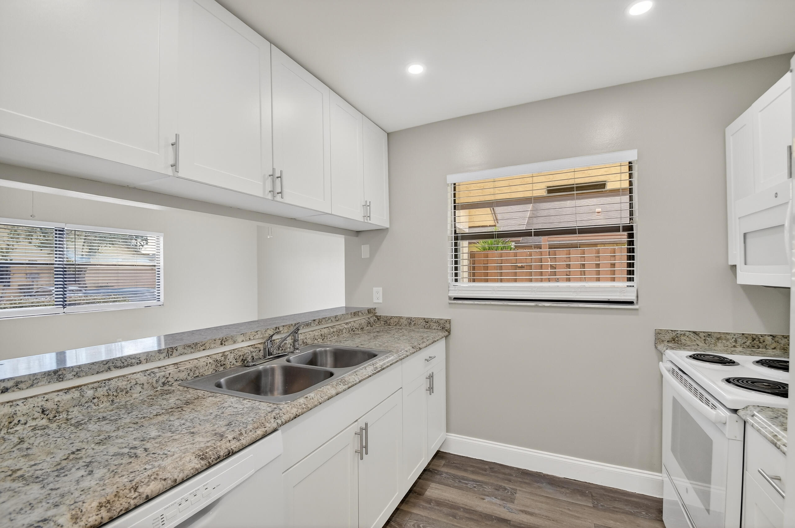 484 Springdale Circle, Unit 48D Palm Springs, FL 33461 - Photo 7 of 59 a kitchen with granite countertop a sink and a stove