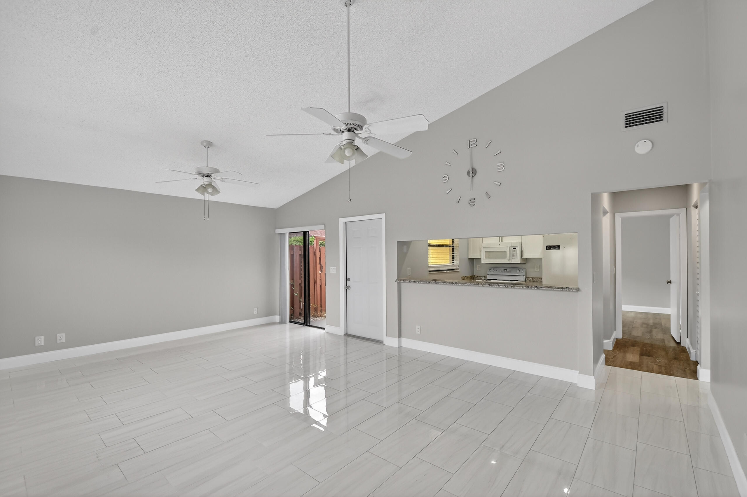 484 Springdale Circle, Unit 48D Palm Springs, FL 33461 - Photo 10 of 59 a view of a livingroom with wooden floor and a ceiling fan