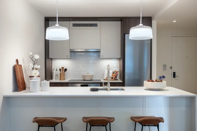 a kitchen with stainless steel appliances a table and chairs in it