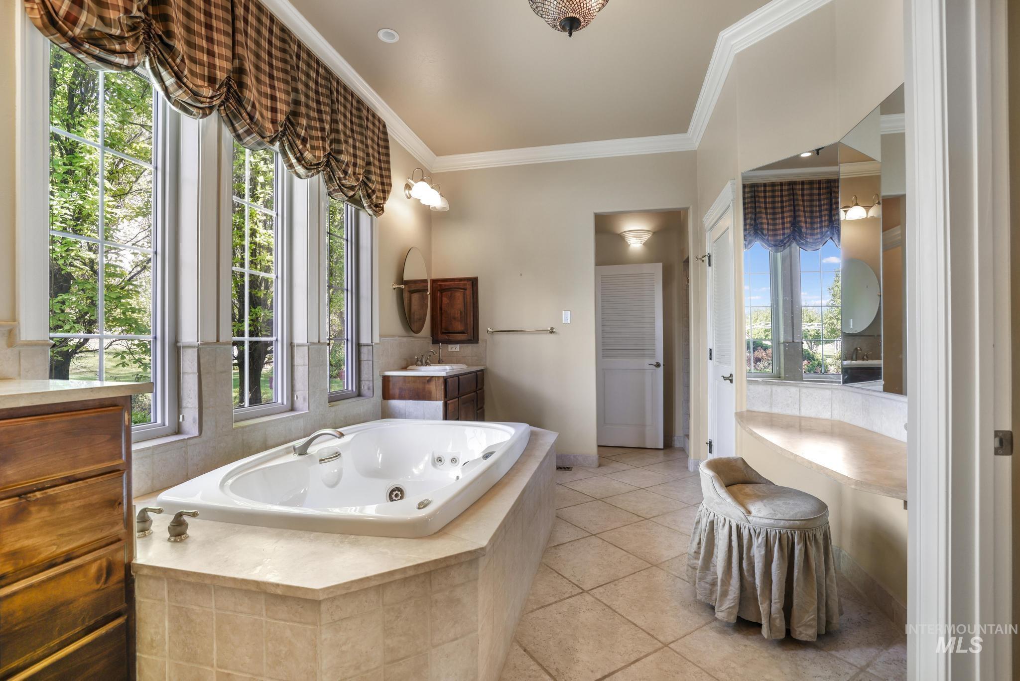 1526 Highway 26 Gooding, ID 83330 - Photo 8 of 48 Bathroom featuring vanity, crown molding, a jetted tub, and light tile patterned floors
