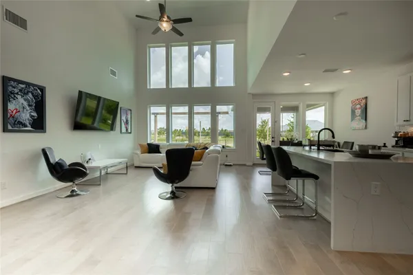 a living room with furniture and a dining table with kitchen view