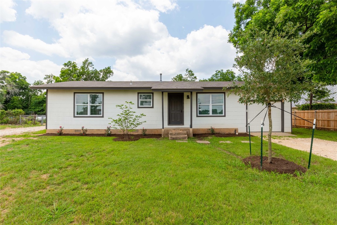 a view of a house with backyard and a tree