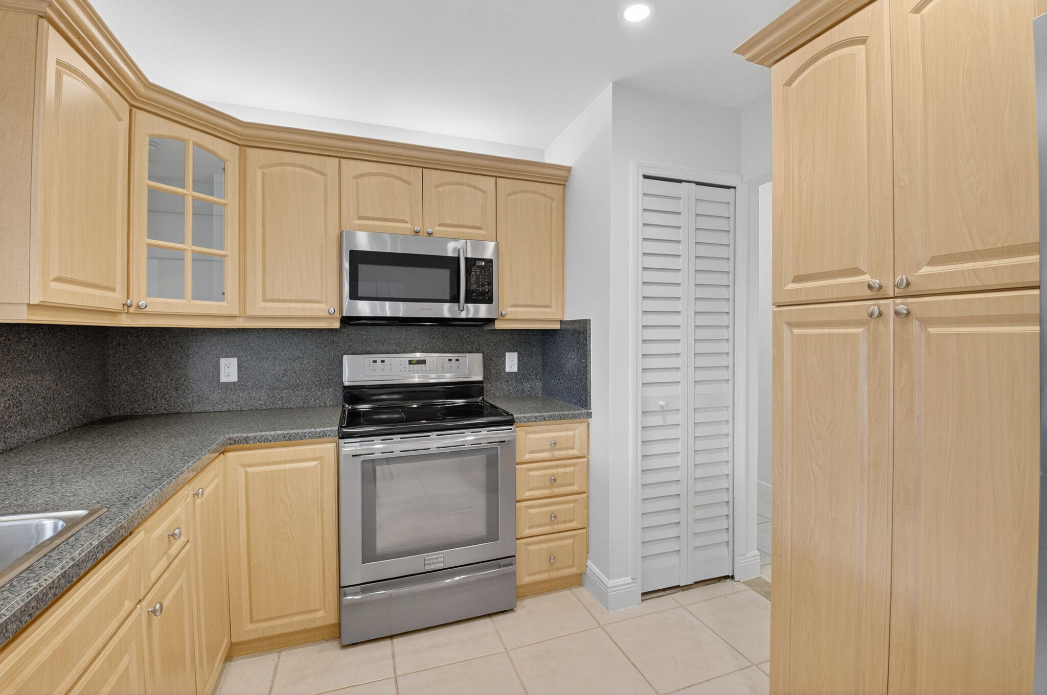 18051 104th Terrace South Boca Raton, FL 33498 - Photo 18 of 46 a kitchen with stainless steel appliances granite countertop a stove and a microwave
