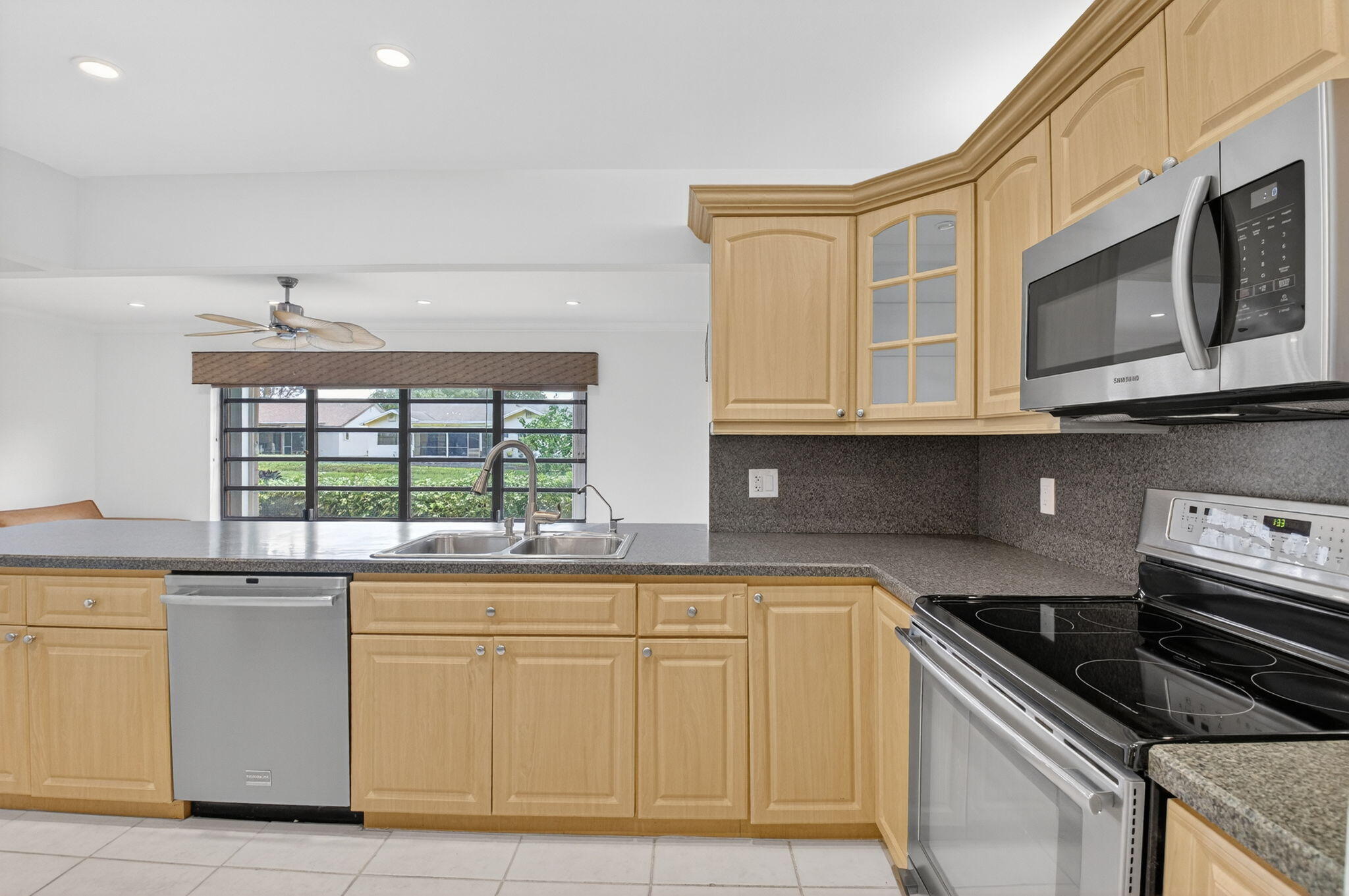 18051 104th Terrace South Boca Raton, FL 33498 - Photo 20 of 46 a kitchen with stainless steel appliances granite countertop a stove and a microwave