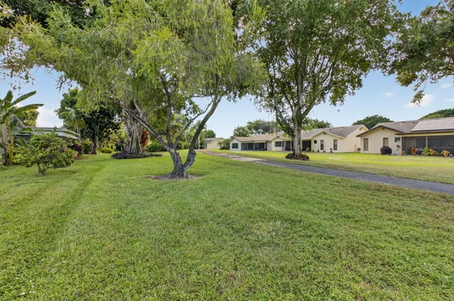 front view of a house with a yard and potted plants