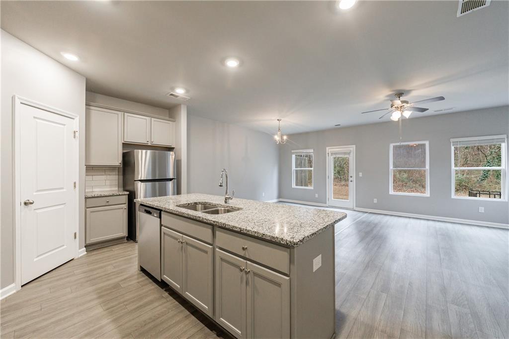 3413 Endurance Court Atlanta, GA 30349 - Photo 11 of 44 a kitchen that has a lot of counter space and wooden floor