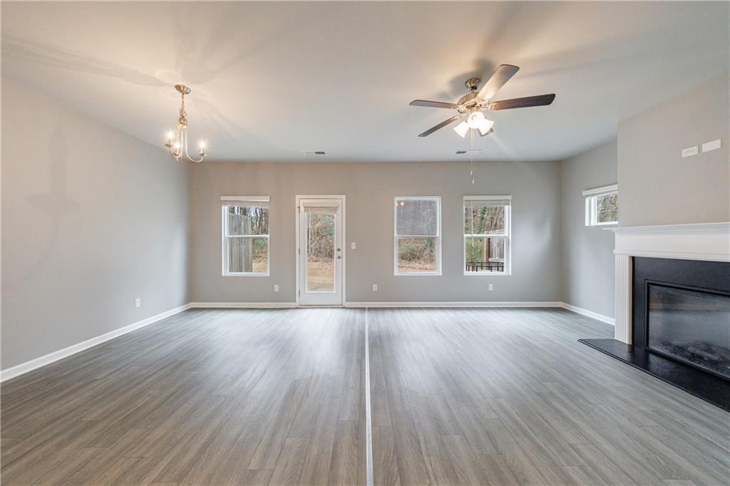 3413 Endurance Court Atlanta, GA 30349 - Photo 19 of 44 an empty room with wooden floor fireplace and windows
