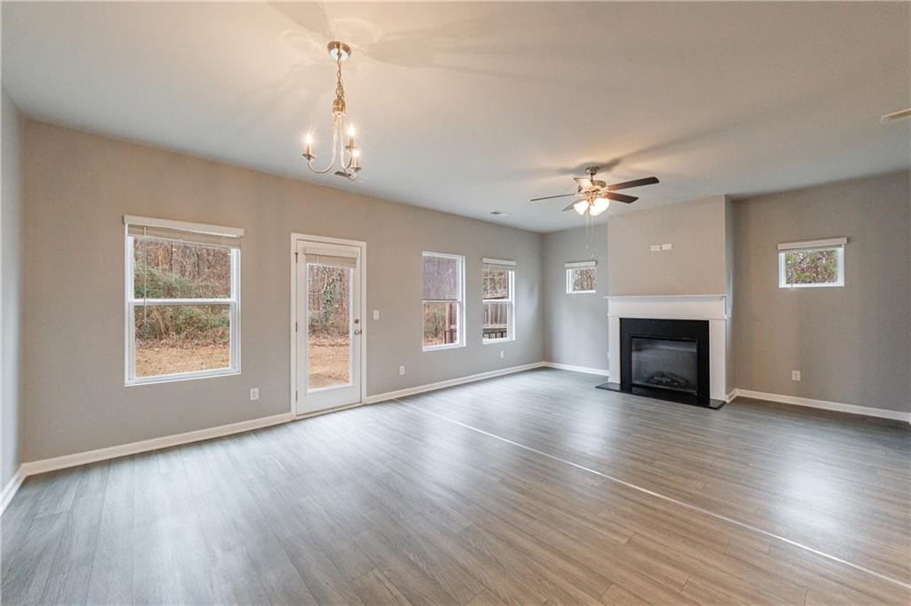 3413 Endurance Court Atlanta, GA 30349 - Photo 20 of 44 an empty room with wooden floor fireplace and windows