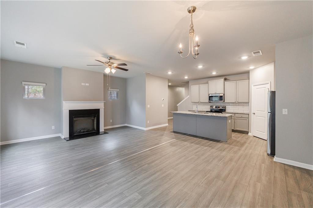 3413 Endurance Court Atlanta, GA 30349 - Photo 22 of 44 a view of kitchen with kitchen island wooden floor and living room