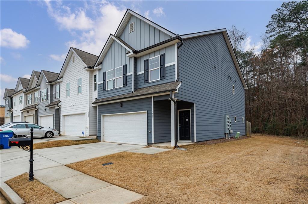 3413 Endurance Court Atlanta, GA 30349 - Photo 3 of 44 a front view of a house with a yard and garage