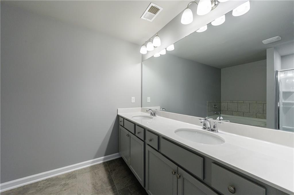 3413 Endurance Court Atlanta, GA 30349 - Photo 33 of 44 a bathroom with a sink a light fixture and a mirror