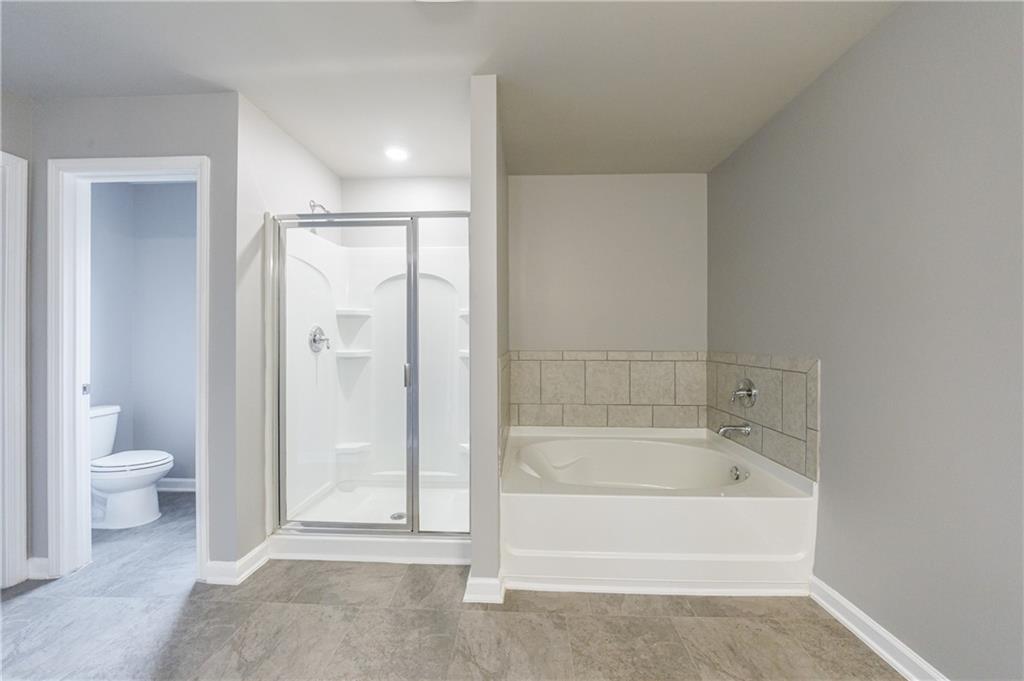 3413 Endurance Court Atlanta, GA 30349 - Photo 34 of 44 a bathroom with a bathtub and a toilet