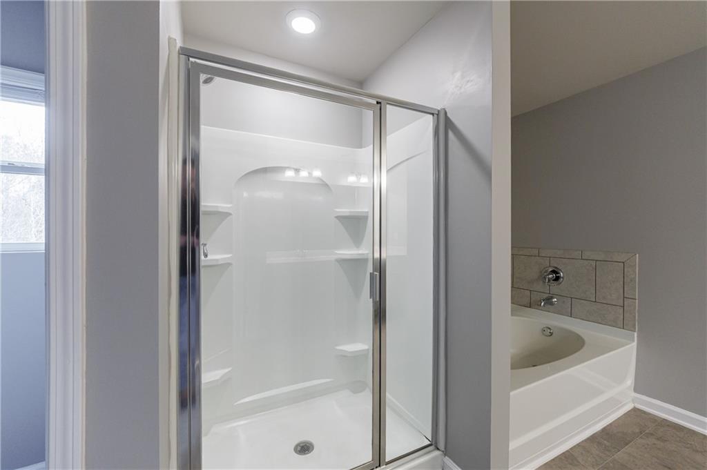 3413 Endurance Court Atlanta, GA 30349 - Photo 36 of 44 a bathroom with a bathtub and a shower