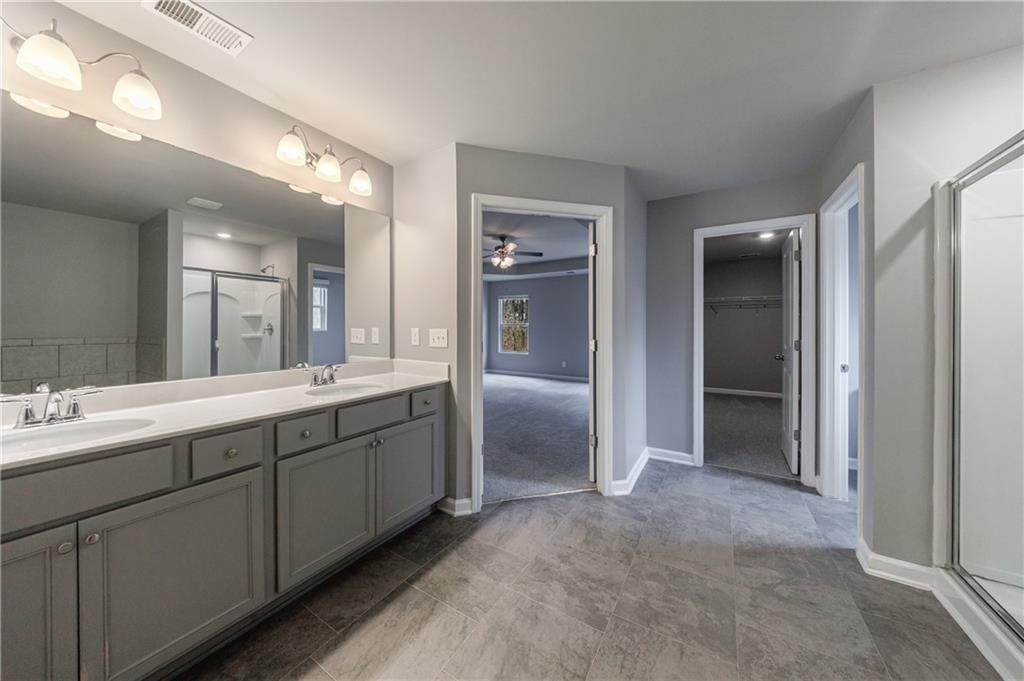 3413 Endurance Court Atlanta, GA 30349 - Photo 38 of 44 a spacious bathroom with double vanity and mirrors