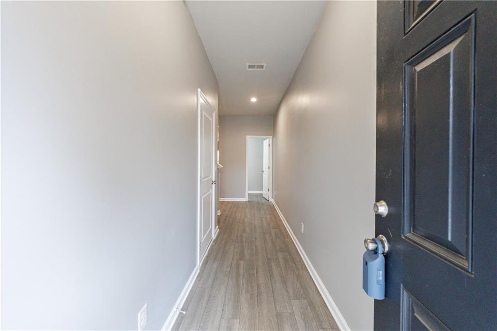 3413 Endurance Court Atlanta, GA 30349 - Photo 7 of 44 a view of a hallway with wooden floor and staircase