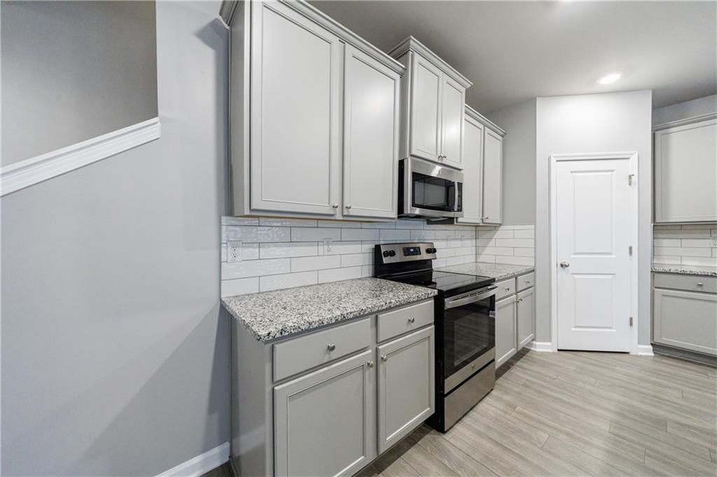 3413 Endurance Court Atlanta, GA 30349 - Photo 10 of 44 a kitchen with stainless steel appliances granite countertop a stove a sink and a refrigerator