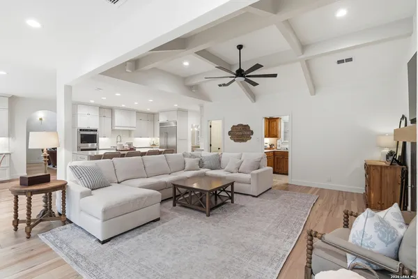 a living room with furniture and a view of kitchen