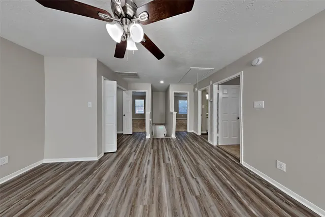 a view of an empty room with wooden floor