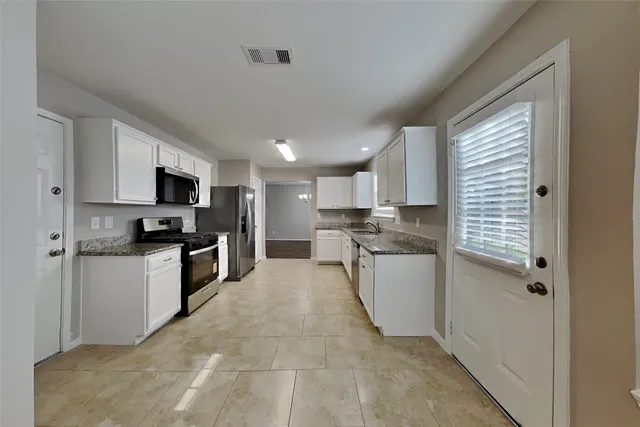 a kitchen with a refrigerator and a stove top oven