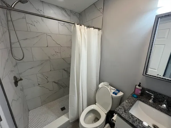 a bathroom with a sink toilet and shower