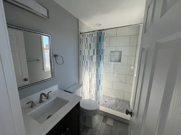 a bathroom with a sink a toilet and shower