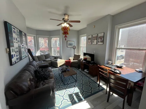 a living room with furniture a chandelier and a window