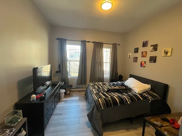 a bedroom with bed tv and window