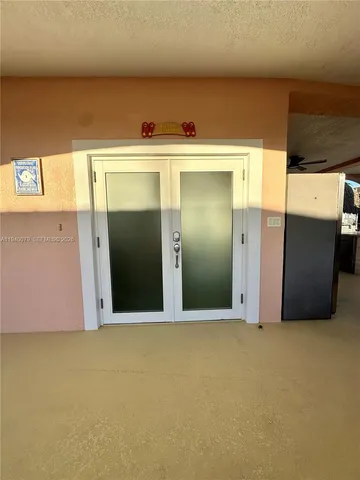 a view of a hallway with potted plants in front of door