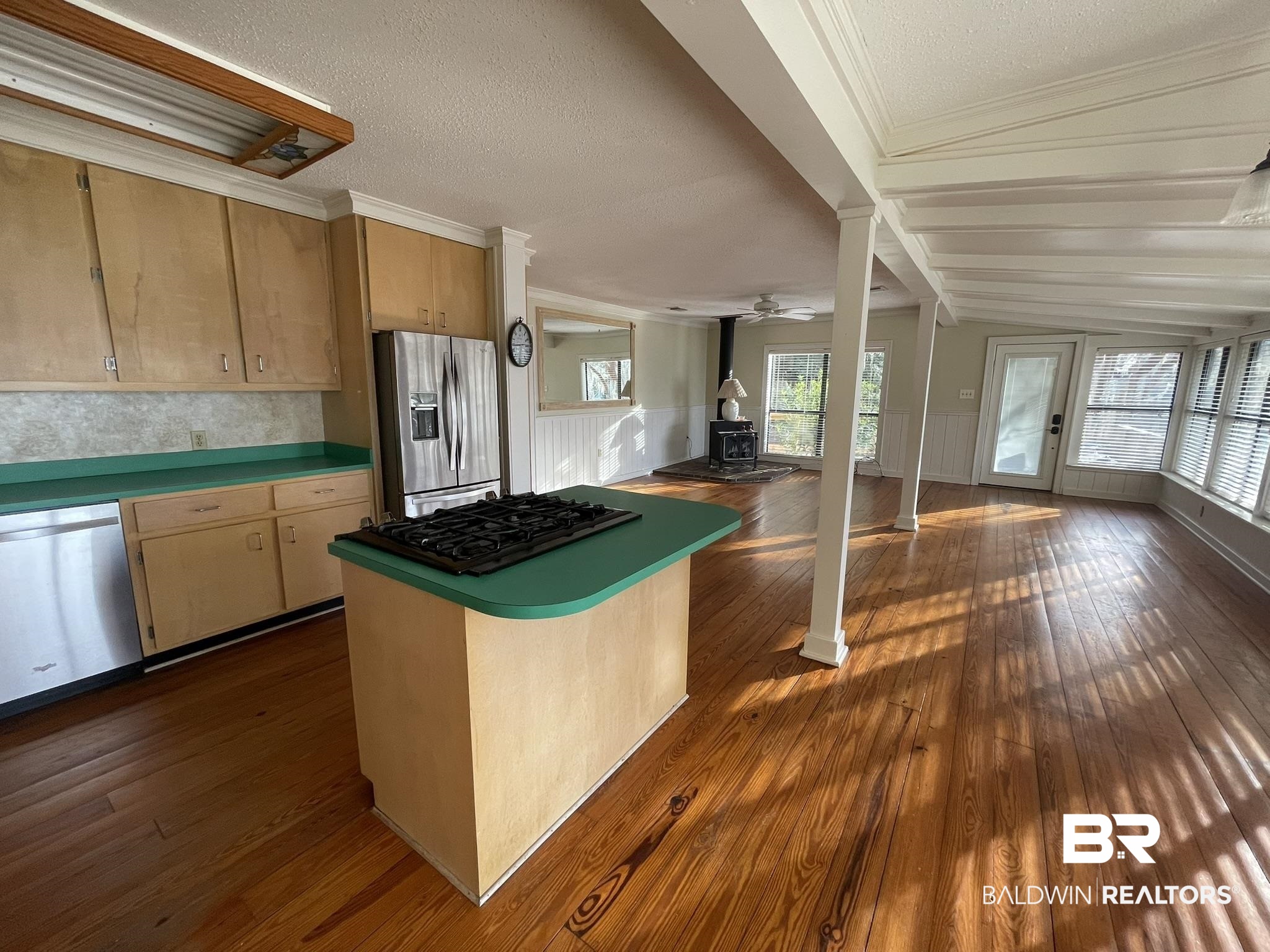 6621 Purvis Road Daphne, AL 36527 - Photo 59 of 59 Kitchen featuring a wood stove, a kitchen island, stainless steel appliances, dark wood-style flooring, and open floor plan