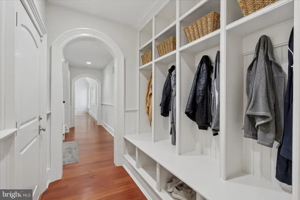 a hallway with white cabinets and a wooden floor