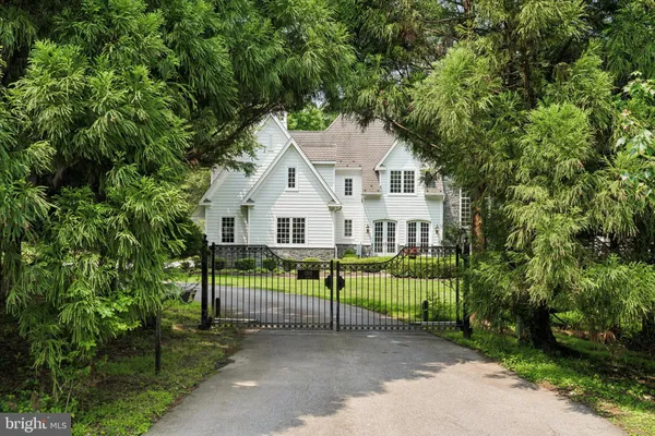 a view of house with outdoor space and trees in the background