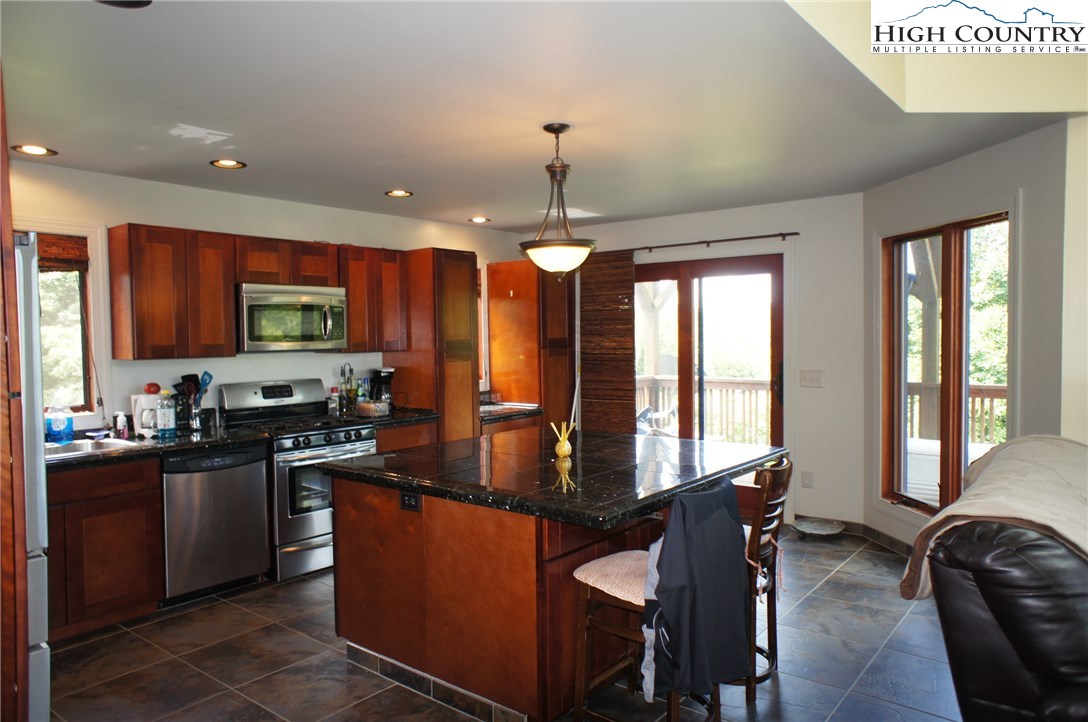 1339 Hopewell Church Road Boone, NC 28607 - Photo 20 of 35 a kitchen with granite countertop a stove top oven a sink a dining table and chairs
