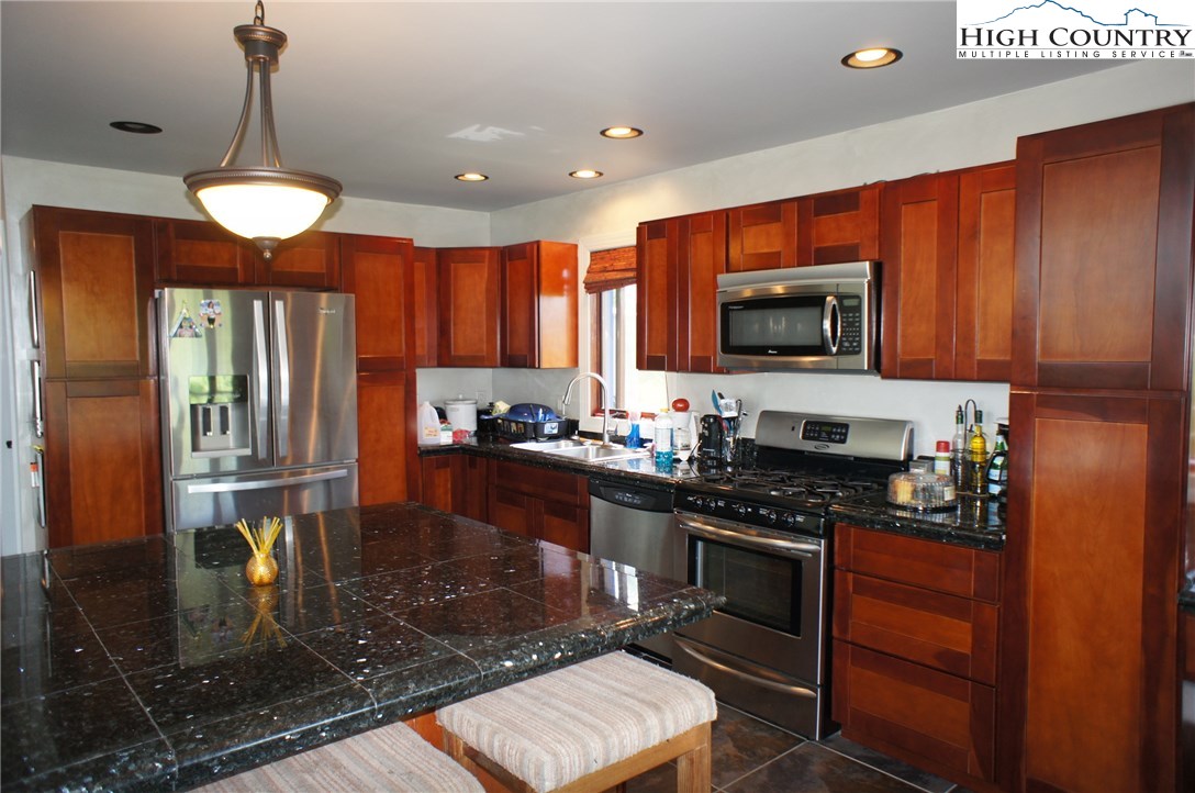 1339 Hopewell Church Road Boone, NC 28607 - Photo 22 of 35 a kitchen with stainless steel appliances granite countertop a stove a sink and a microwave