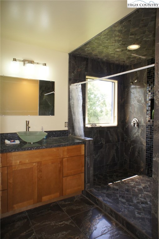 1339 Hopewell Church Road Boone, NC 28607 - Photo 30 of 35 a bathroom with a granite countertop sink a mirror and shower