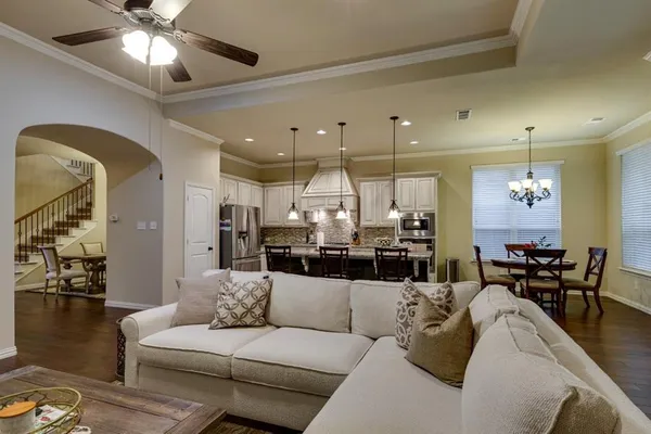 a living room with furniture kitchen view and a chandelier