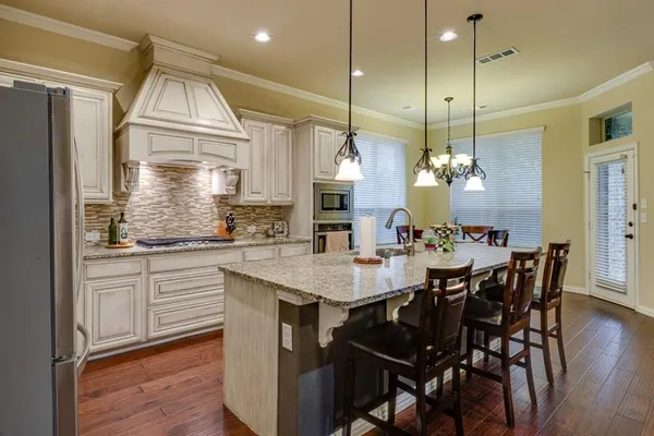 a kitchen with cabinets appliances and a dining table