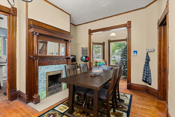 a dining room with furniture a fireplace and wooden floor