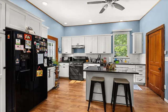 a kitchen with stainless steel appliances granite countertop a refrigerator and a stove top oven