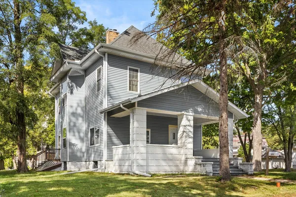 a front view of a house with a garden and trees