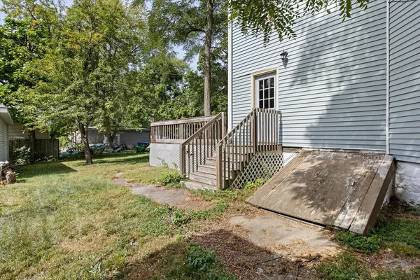 a view of a house with backyard and a tree