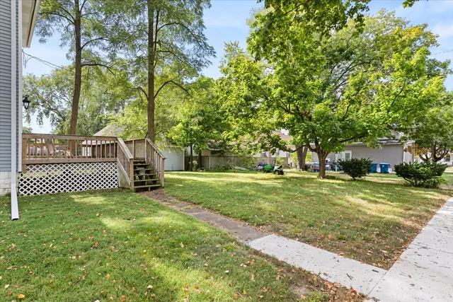 a view of a deck with wooden floor and fence next to a yard