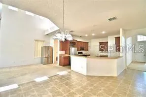 a view of kitchen with kitchen island microwave and refrigerator
