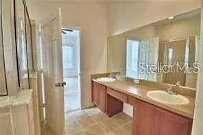 a bathroom with a granite countertop sink a mirror and a shower