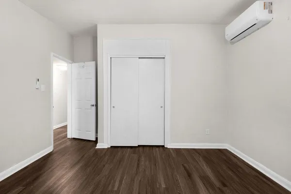 a view of an empty room with wooden floor