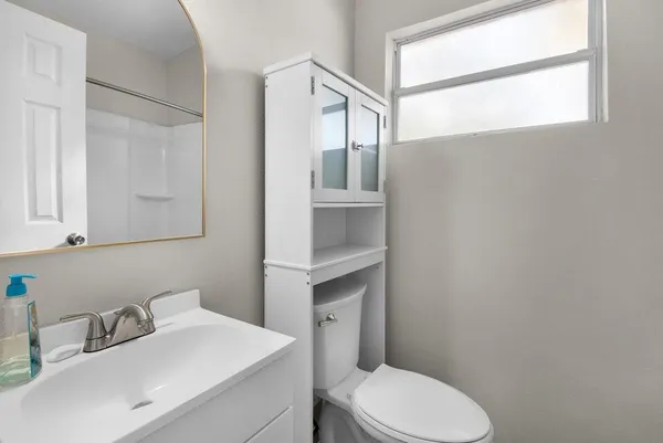 a bathroom with a toilet sink and mirror